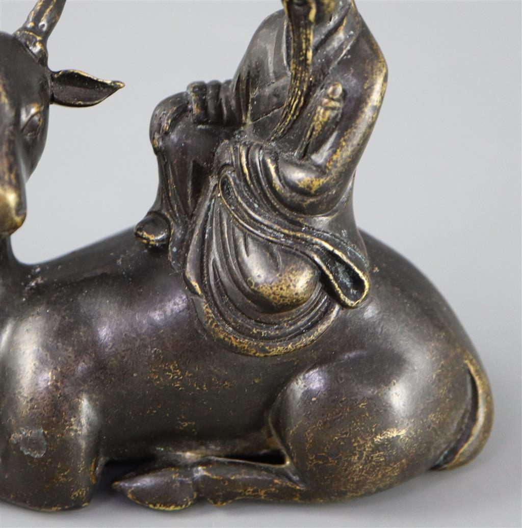 A Chinese late Ming bronze group of an immortal seated on a recumbent deer, 12.5cm long